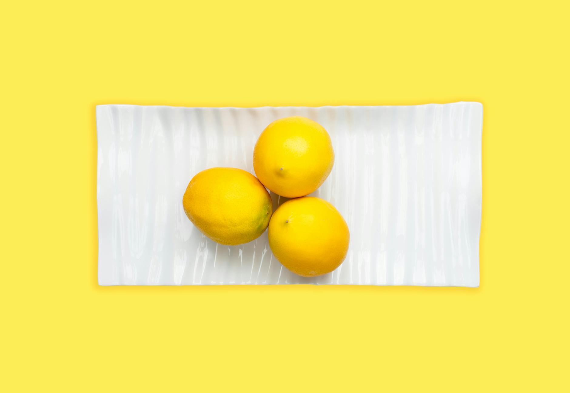 Bright yellow lemons on a pastel background, symbolizing freshness and optimal sensation