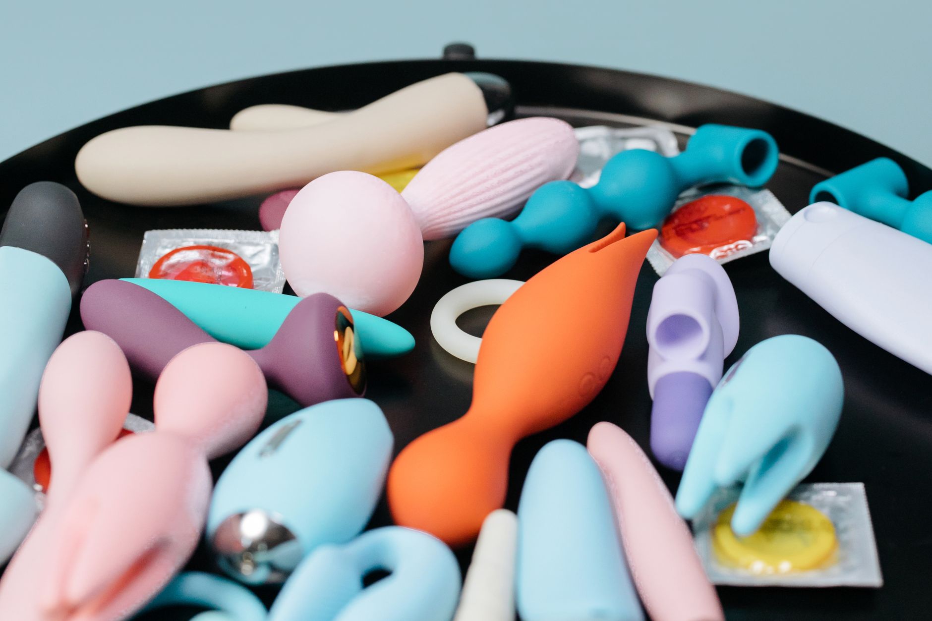 Woman holding two colorful vibrators with confidence and calm expression