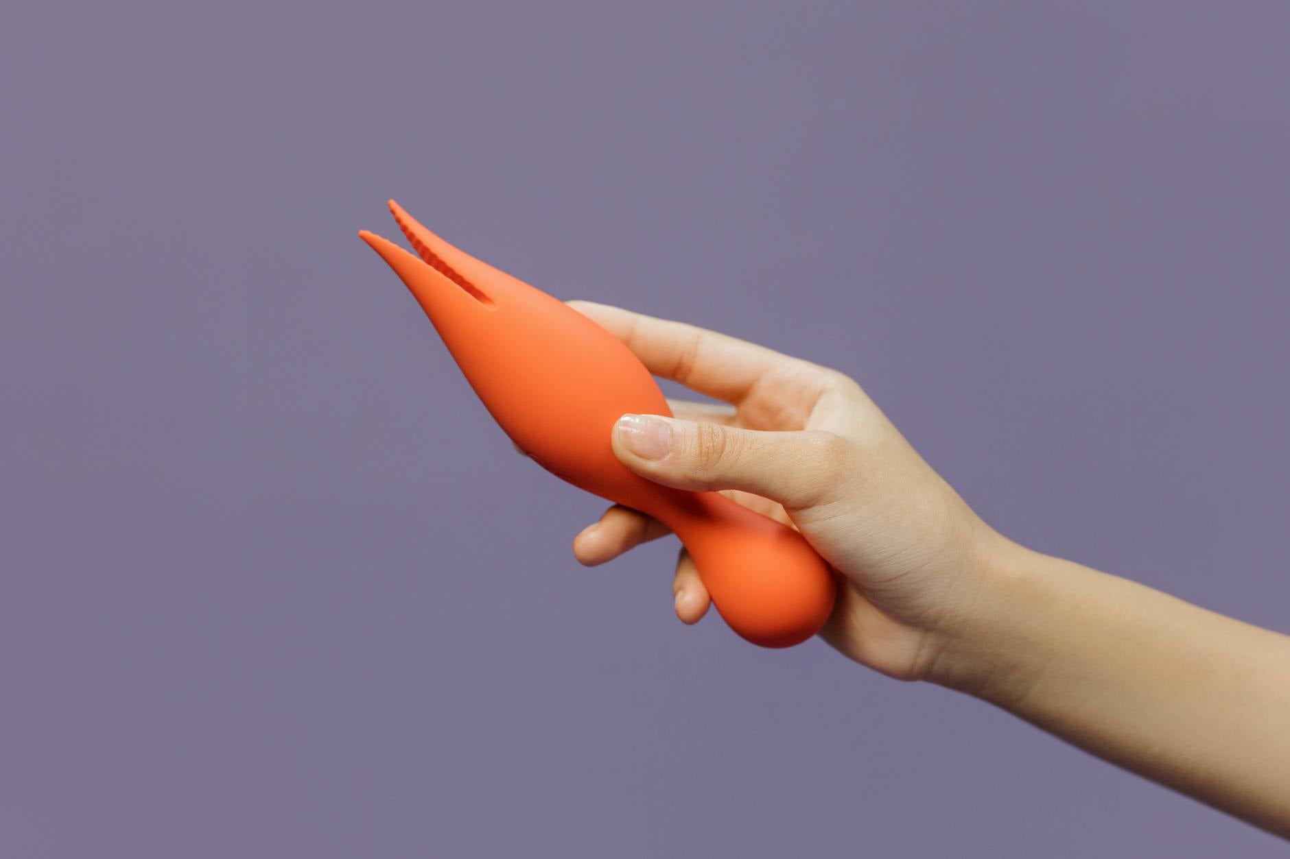 Close-up of a hand holding a vibrator against a minimalist backdrop, symbolizing the gentle reconnection with sensation.
