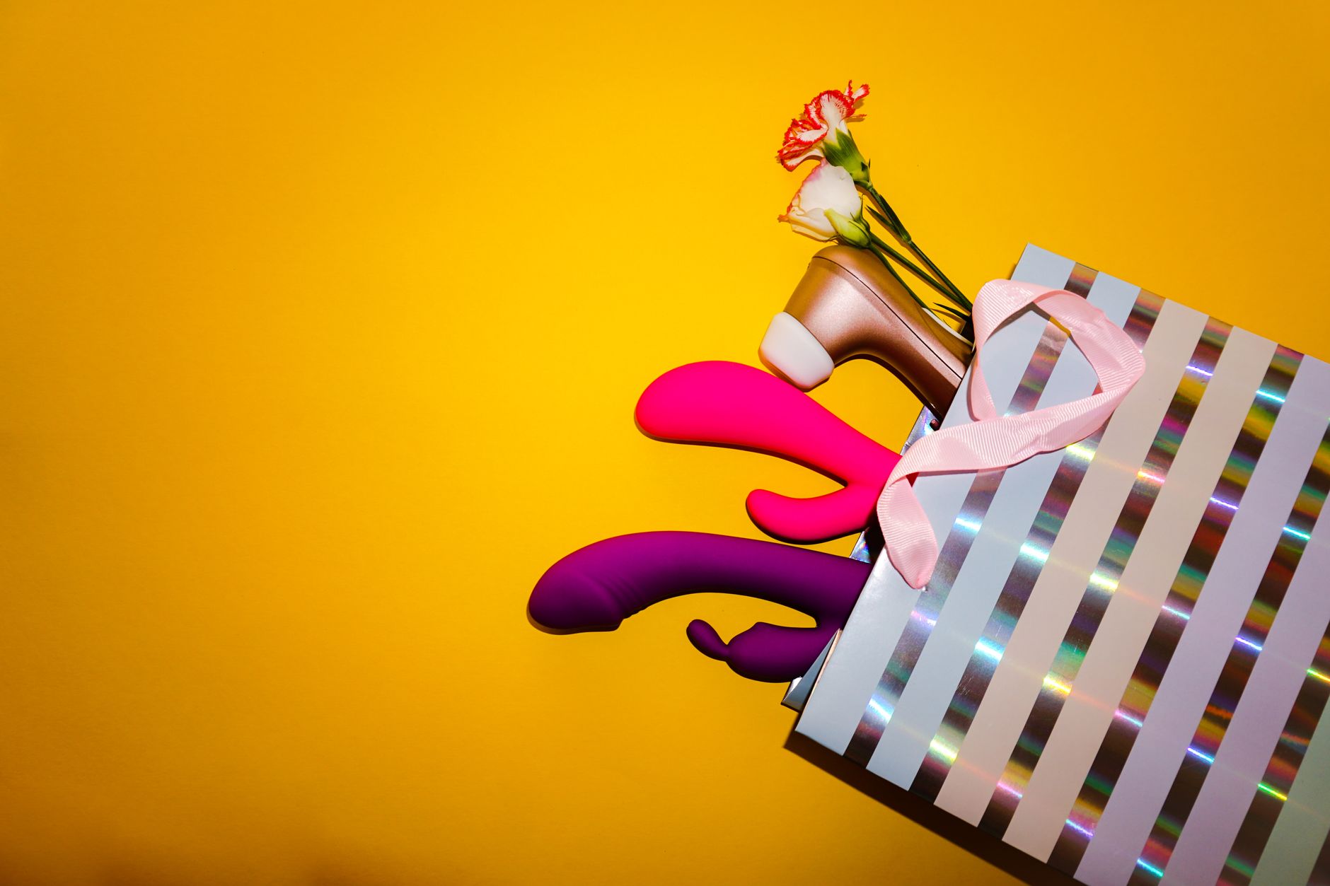 Vibrant collection of lemon-colored clitoral vibrators arranged with fresh lemons and flowers on a bright yellow background.