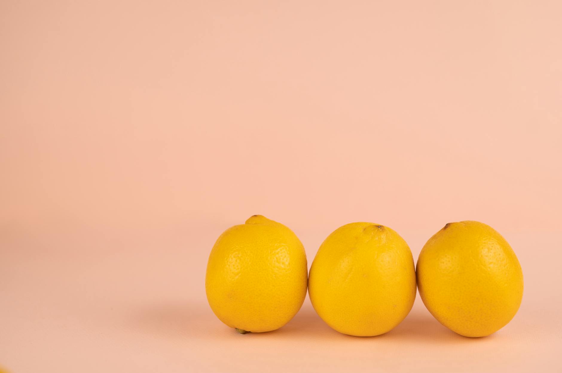 Fresh bright lemons arranged on a white surface, symbolizing the design inspiration behind lemon vibrators